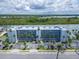 Aerial view of complex and parking with water view, landscape, and palm trees at 18325 Gulf Blvd # 407, Redington Shores, FL 33708