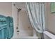 Bright bathroom featuring a white tub with showerhead and blue patterned shower curtain at 18325 Gulf Blvd # 407, Redington Shores, FL 33708