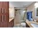 Well-lit bathroom with granite countertops, wood cabinets, and a tiled walk-in shower at 18325 Gulf Blvd # 407, Redington Shores, FL 33708