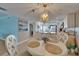 Coastal dining area with modern lighting fixture, with an open view to a kitchen at 18325 Gulf Blvd # 407, Redington Shores, FL 33708