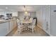 Dining area features white chairs, decor, and modern lighting fixture and tile floors at 18325 Gulf Blvd # 407, Redington Shores, FL 33708