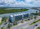 Waterfront condo complex with palm trees and parking spaces on a sunny day at 18325 Gulf Blvd # 407, Redington Shores, FL 33708