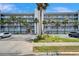 Apartment building complex with palm trees, a fire hydrant, and parking spots under a blue sky at 18325 Gulf Blvd # 407, Redington Shores, FL 33708
