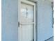 Exterior view of a light blue condo's front door with glass pane and unit number at 18325 Gulf Blvd # 407, Redington Shores, FL 33708