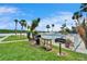 Community grilling area with lush grass, tropical plants, and a serene waterfront view at 18325 Gulf Blvd # 407, Redington Shores, FL 33708