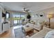 Bright living room leading to a balcony, with comfortable seating and coastal-themed decor at 18325 Gulf Blvd # 407, Redington Shores, FL 33708