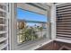 Bright window view of the street, palm trees, buildings, and a glimpse of the ocean at 18325 Gulf Blvd # 407, Redington Shores, FL 33708