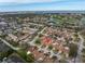 Aerial view of a residential neighborhood with a golf course and waterfront views in the distance at 2267 Heron Cir, Clearwater, FL 33762