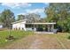 Charming single-story home with a carport and screened porch surrounded by a green yard and mature trees at 309 4Th Sw Ave, Ruskin, FL 33570