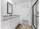 Bright bathroom featuring white cabinets, stone countertops, black fixtures and shower with glass door at 4546 Padgette St, North Port, FL 34291