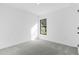 Neutral bedroom featuring gray carpet, white walls, and an exterior window at 4546 Padgette St, North Port, FL 34291