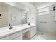 Bathroom featuring double sinks, ample counter space, and a glass-enclosed shower with safety bar at 5215 New Brittany Ln, Zephyrhills, FL 33541