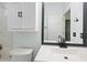 Brightly lit bathroom featuring a modern toilet, sink and vanity, storage cabinet, and fixtures at 5215 New Brittany Ln, Zephyrhills, FL 33541