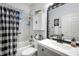 Bathroom featuring a shower and tub combination, gray cabinets, a large mirror, and black hardware at 5215 New Brittany Ln, Zephyrhills, FL 33541