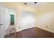 Bedroom with hardwood floors, closet, and access to the hallway and another bedroom at 5215 New Brittany Ln, Zephyrhills, FL 33541