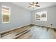 Bedroom with ceiling fan, natural light from two windows, and stylish wood flooring at 5215 New Brittany Ln, Zephyrhills, FL 33541