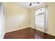A sunny bedroom with dark wood floors, ceiling fan, and large windows for natural light at 5215 New Brittany Ln, Zephyrhills, FL 33541