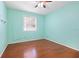 A vibrant bedroom with a window letting in natural light and hardwood floors at 5215 New Brittany Ln, Zephyrhills, FL 33541