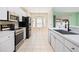 Well-lit kitchen with stainless steel appliances, white cabinets, and a breakfast nook at 5215 New Brittany Ln, Zephyrhills, FL 33541