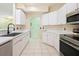 Spacious kitchen with white cabinetry, stainless steel appliances, and tile flooring at 5215 New Brittany Ln, Zephyrhills, FL 33541