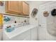 Functional laundry room with washer, dryer, storage, and convenient hanging rod at 5215 New Brittany Ln, Zephyrhills, FL 33541