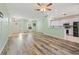 Open-concept living area with durable wood-look floors, showcasing the kitchen and front entrance at 5215 New Brittany Ln, Zephyrhills, FL 33541