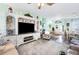 Cozy living room features stylish furniture and large TV, creating a comfortable and inviting space at 5215 New Brittany Ln, Zephyrhills, FL 33541
