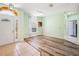 Open-concept living space with light green walls, wood-look flooring, and a welcoming front entrance at 5215 New Brittany Ln, Zephyrhills, FL 33541