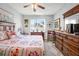 Comfortable bedroom with a ceiling fan, natural light, and plenty of dresser space at 5215 New Brittany Ln, Zephyrhills, FL 33541