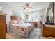 Inviting bedroom featuring a ceiling fan, natural light, and charming decor at 5215 New Brittany Ln, Zephyrhills, FL 33541