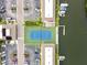 An aerial view of a tennis court, parking, and boat docks in a waterfront community at 8829 Bay Pointe Dr # 205, Tampa, FL 33615