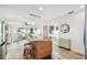 Bright, open-concept living area featuring a kitchen island, travertine floors, and water views at 8829 Bay Pointe Dr # 205, Tampa, FL 33615