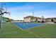 A tennis court is surrounded by a fence, trees, and the apartment buildings in the complex at 8829 Bay Pointe Dr # 205, Tampa, FL 33615
