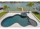 Aerial view of a custom pool and spa, with a dock and waterfront views at 17059 Dolphin Dr, North Redington Beach, FL 33708