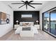 Modern bedroom with a statement wall, sleek ceiling fan, and waterfront views at 17059 Dolphin Dr, North Redington Beach, FL 33708
