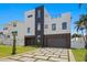 Striking modern home with a two-car garage and a geometrically patterned driveway at 17059 Dolphin Dr, North Redington Beach, FL 33708
