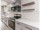 Bright kitchen features stainless steel appliances, white cabinets, and floating shelves at 3721 9Th S Ave, St Petersburg, FL 33711