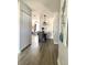 View of hallway with gray wood floors, leading to a dining area and living room with blue sofa at 4684 25Th S Ave, St Petersburg, FL 33711