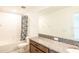 Bathroom featuring granite countertops, dark wooden cabinets, shower and tub combo, and a large mirror at 7815 Bronze Oak Dr, Wesley Chapel, FL 33545