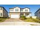 Charming two-story home with a brick driveway, a two-car garage, and manicured landscaping at 7815 Bronze Oak Dr, Wesley Chapel, FL 33545