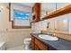 Traditional bathroom features wooden cabinets, a sink, a toilet and window for natural light at 8716 Hickorywood Ln, Tampa, FL 33615