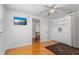 Bedroom featuring hardwood floors, TV, closet, and a doorway leading to the hallway at 8716 Hickorywood Ln, Tampa, FL 33615