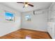 Bedroom with hardwood floors, ceiling fan, windows, and AC unit for comfortable living at 8716 Hickorywood Ln, Tampa, FL 33615