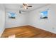 Bedroom featuring hardwood floors, a ceiling fan, and two windows at 8716 Hickorywood Ln, Tampa, FL 33615