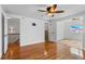 Bedroom with hardwood flooring, a ceiling fan, an en-suite bathroom, and a staircase at 8716 Hickorywood Ln, Tampa, FL 33615