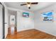 Bright bedroom featuring hardwood floors, a window and a ceiling fan for comfort at 8716 Hickorywood Ln, Tampa, FL 33615