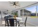 Bright dining area with views of the backyard pool and modern landscaping, ceiling fan and marble table at 8716 Hickorywood Ln, Tampa, FL 33615