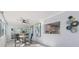 Bright dining area featuring modern decor, stylish art, modern fan and an open window to the kitchen at 8716 Hickorywood Ln, Tampa, FL 33615