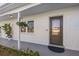 Charming home features a white brick exterior and a stylish front door with decorative flower basket at 8716 Hickorywood Ln, Tampa, FL 33615