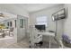 Modern office featuring large windows, stylish white desk and chair and views to a living room at 8716 Hickorywood Ln, Tampa, FL 33615